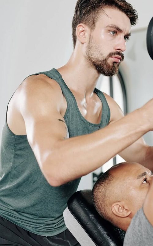fitness-trainer-helping-client.jpg