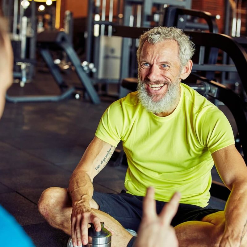 happy-middle-aged-man-discussing-something-with-fitness-instructor-or-personal-trainer-and-smiling.jpg