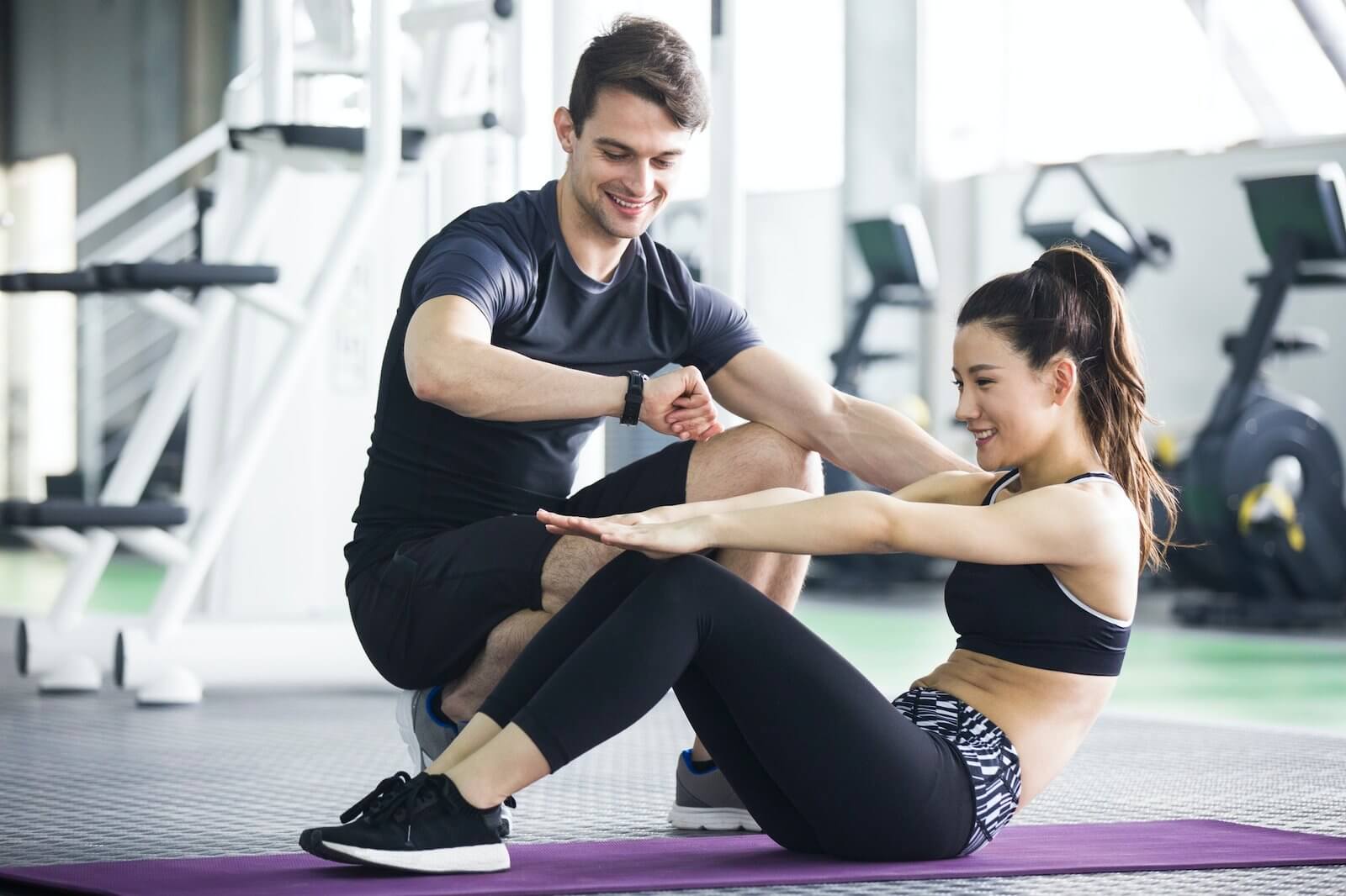 young-woman-working-with-trainer-at-gym.jpg